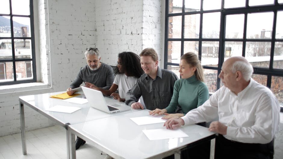 A group of professionals discussing ideas around a table in a bright, modern office setting.